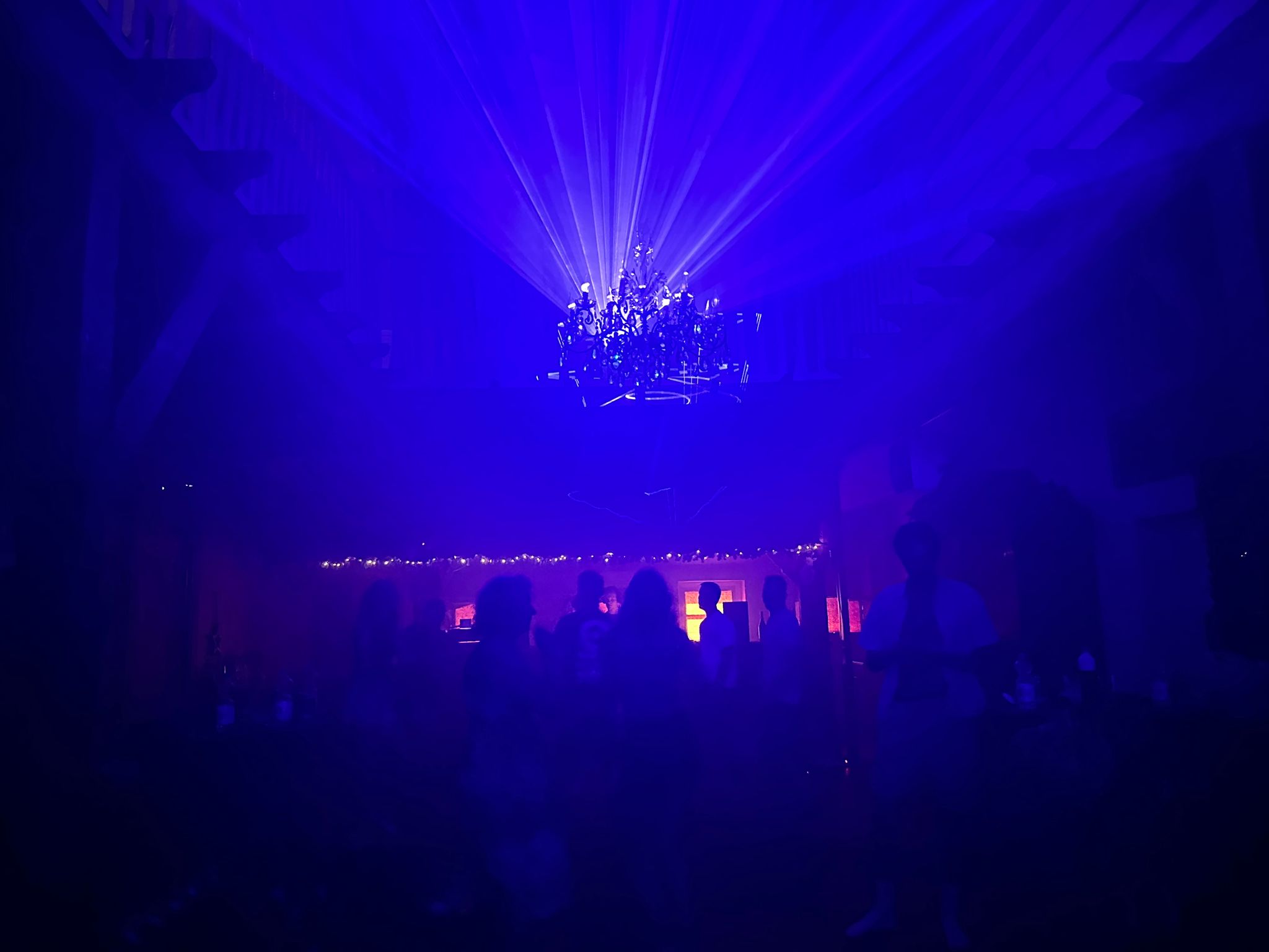 Lasershow gericht op een kroonluchter in een feestlocatie
